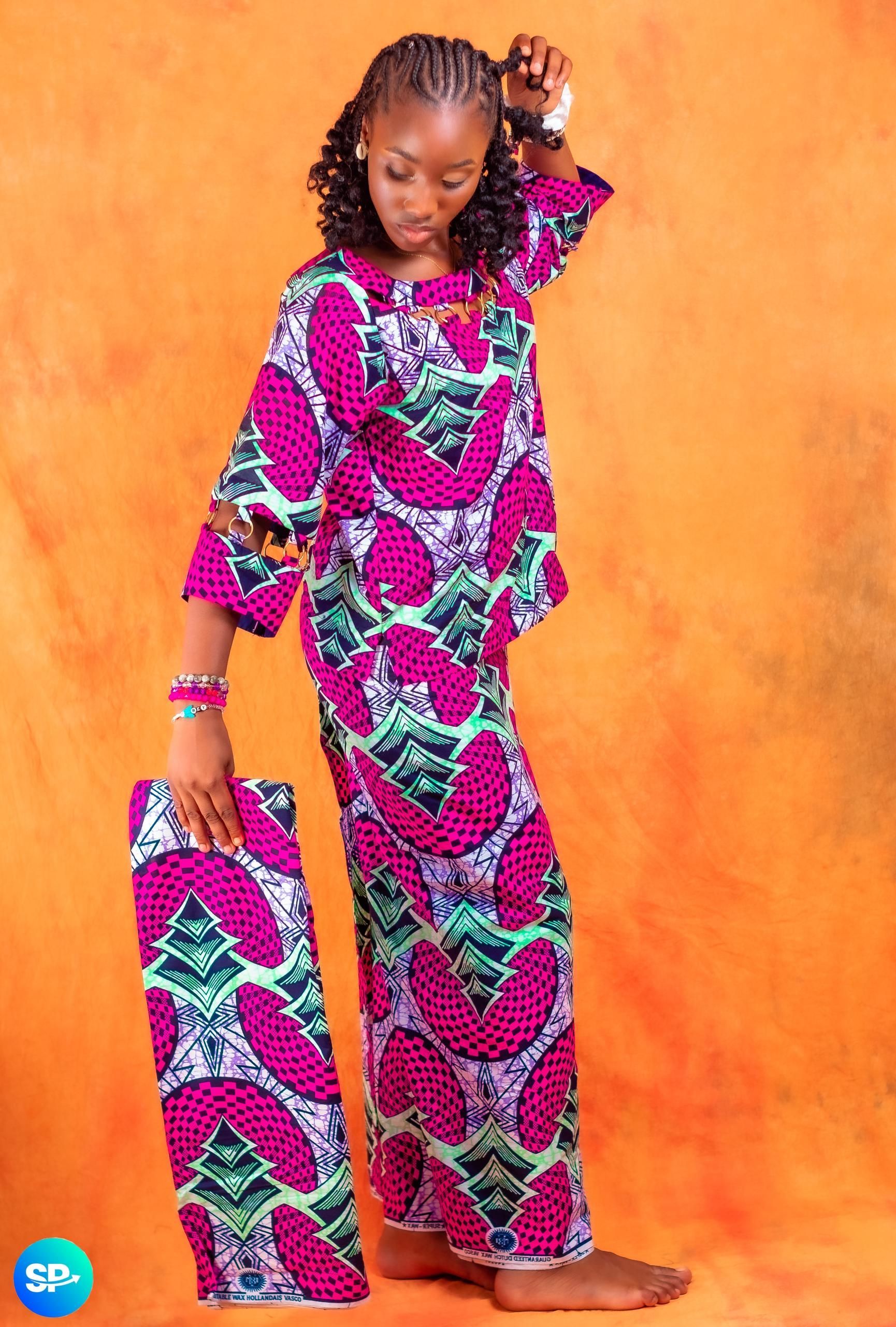 Femme portant une robe à motifs roses et blancs et tenant un tissu assorti.