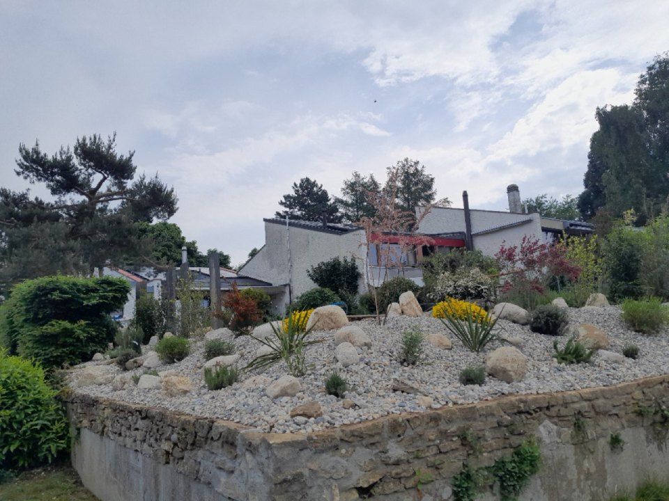 Un jardin de rocaille avec une maison en arrière-plan