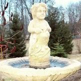 Eine Statue eines Kindes, das auf einem Brunnen steht.