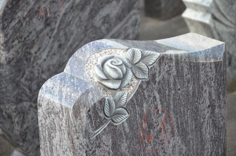 Ein Grabstein mit einer eingemeißelten Rose.