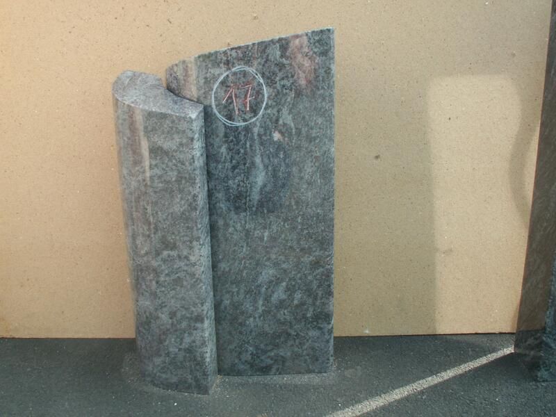 Auf einem Tisch steht eine graue Steinskulptur.