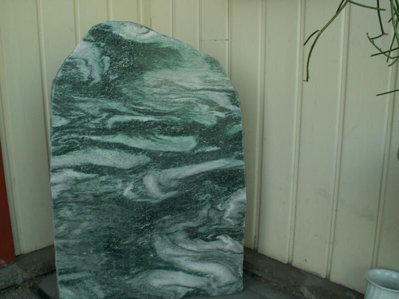 Auf einem Holztisch liegt eine grün-weiße Marmorplatte.