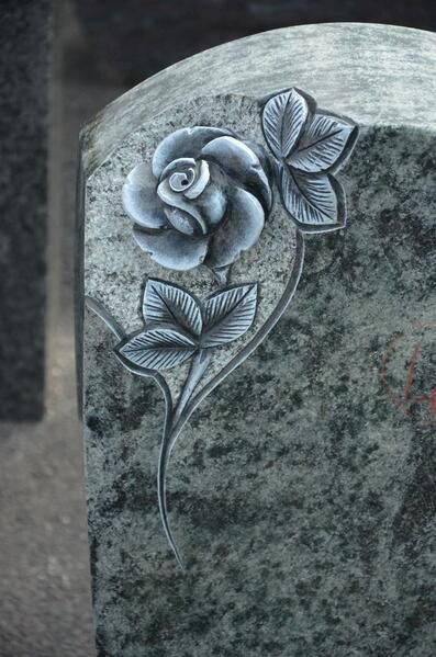 Ein Grabstein mit zwei eingemeißelten Rosen.