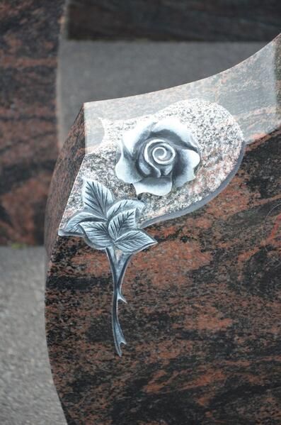 Eine Nahaufnahme einer Rosenstatue auf einem Grab.