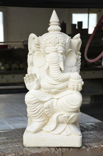 Eine weiße Elefantenstatue sitzt auf einem Tisch