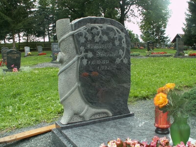 Ein Grab auf einem Friedhof mit einer Vase mit Blumen davor