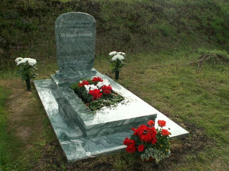 Ein Grab mit Blumen darauf auf einem Friedhof.