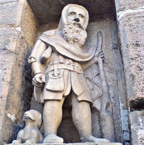 Eine Steinstatue eines Mannes mit Bart und einem Hund