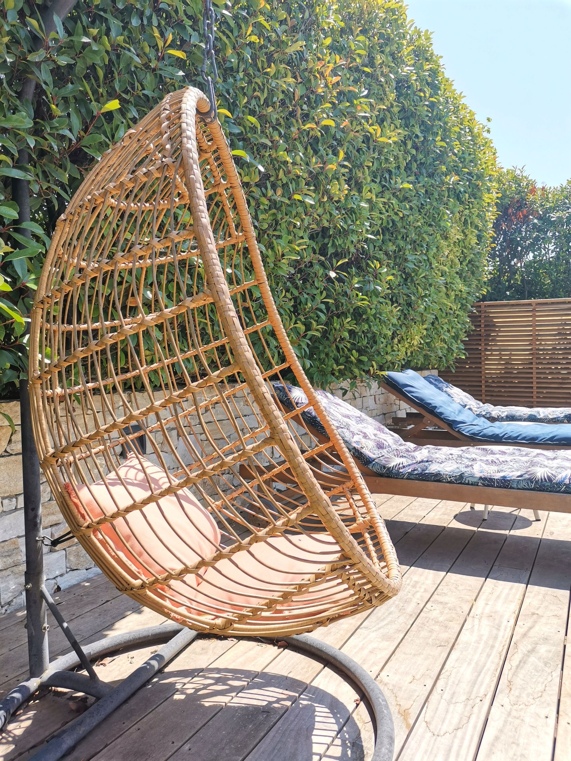 Fauteuil de jardin en rotin et chaises longues sur terrasse à Aix-en-Provence