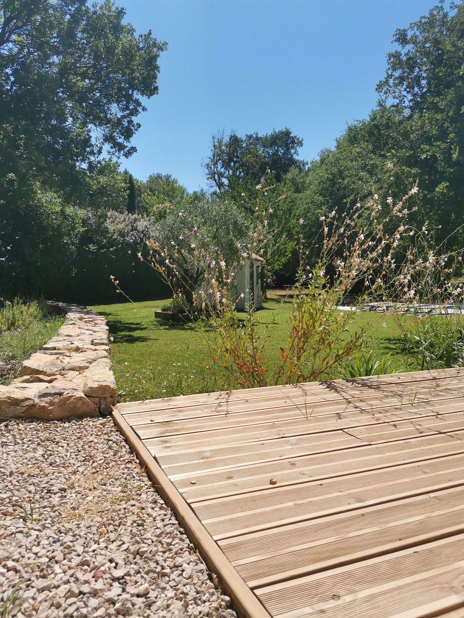 Vue sur l'arrière du jardin avec cabanon et grands arbres à Aix-en-Provence