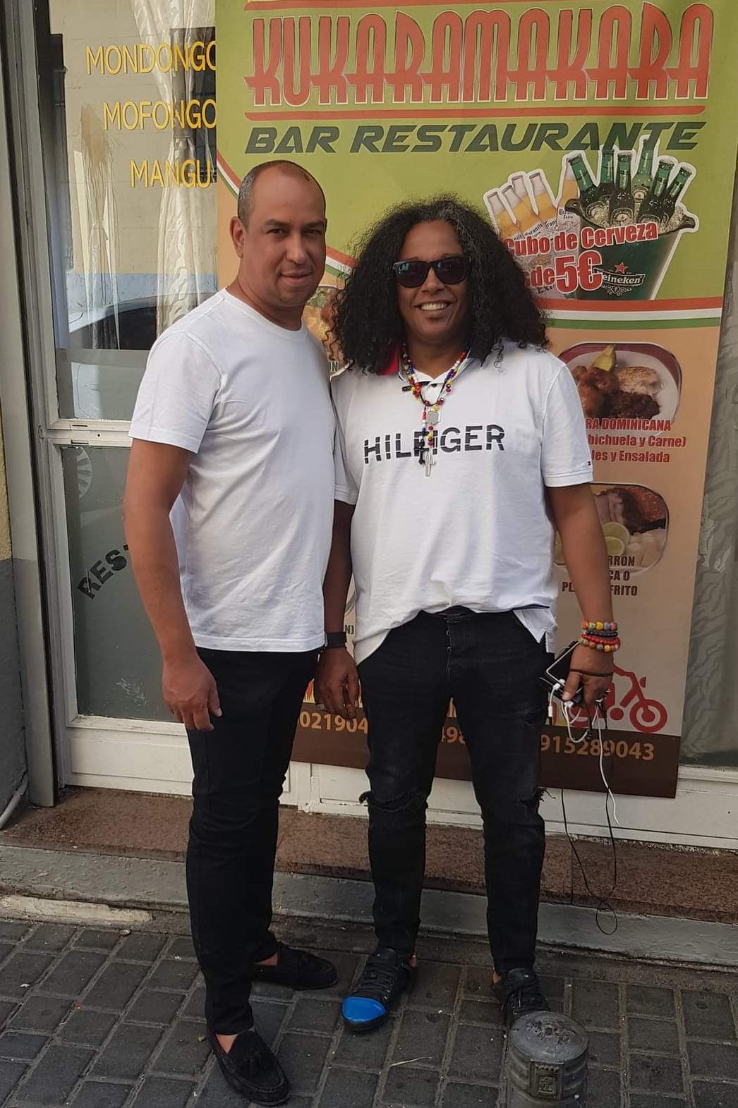 Dos hombres están afuera de un restaurante. 