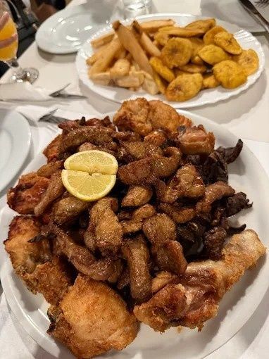 Plato de comida frita con gajo de limón. Incluye pollo frito, papas fritas y plátano macho.