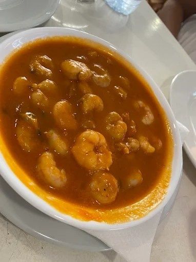 Camarones en salsa de naranja servidos en un tazón blanco.