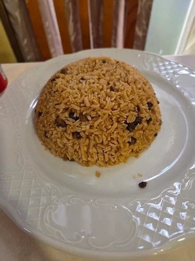 Pilaf de arroz integral, servido en un plato con estampado blanco.