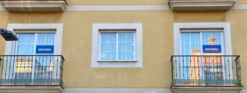 Un edificio con dos balcones y un cartel que dice 'avenida' en él.