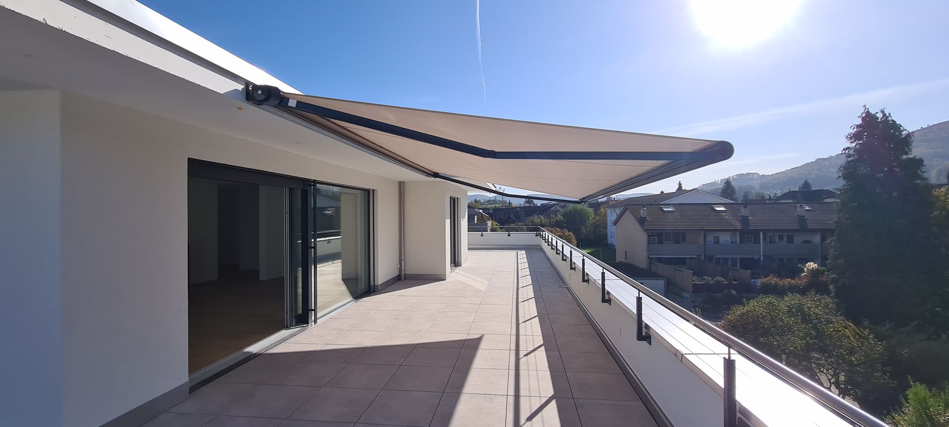 Balkon mit einziehbarer Markise, Glastüren und malerischer Aussicht.