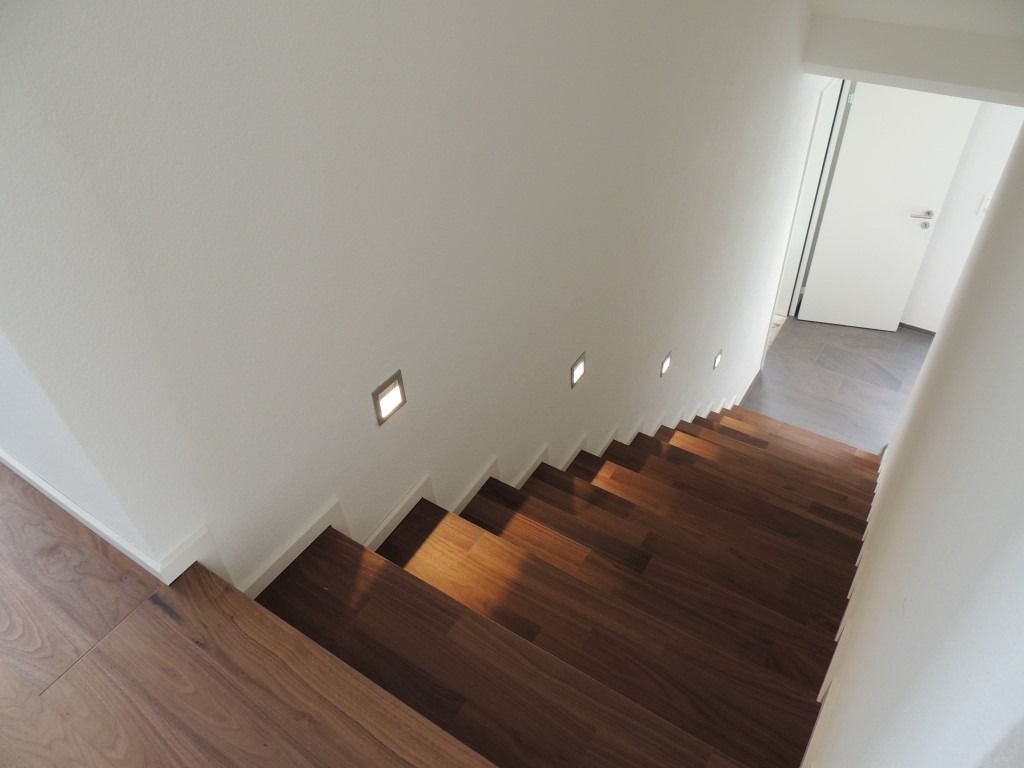 Eine Treppe mit Holzstufen und einer weißen Wand
