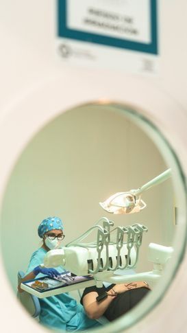 Un dentista está trabajando con un paciente en un consultorio dental.