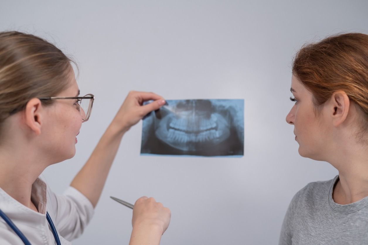 Un dentista está mirando una radiografía de los dientes de un paciente.