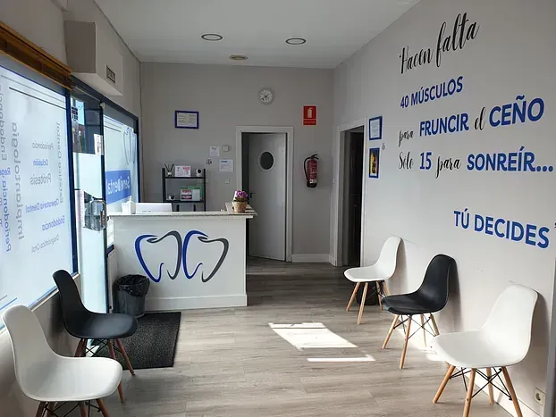 Una sala de espera con sillas y un mostrador en un consultorio dental.