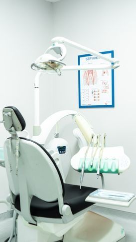 Una silla dental en un consultorio dental con un cartel en la pared.