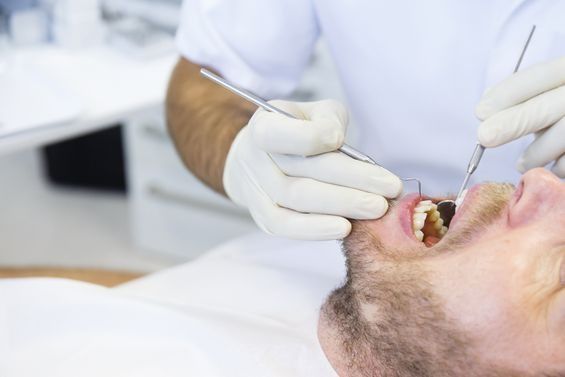 Un hombre está siendo examinado por un dentista.