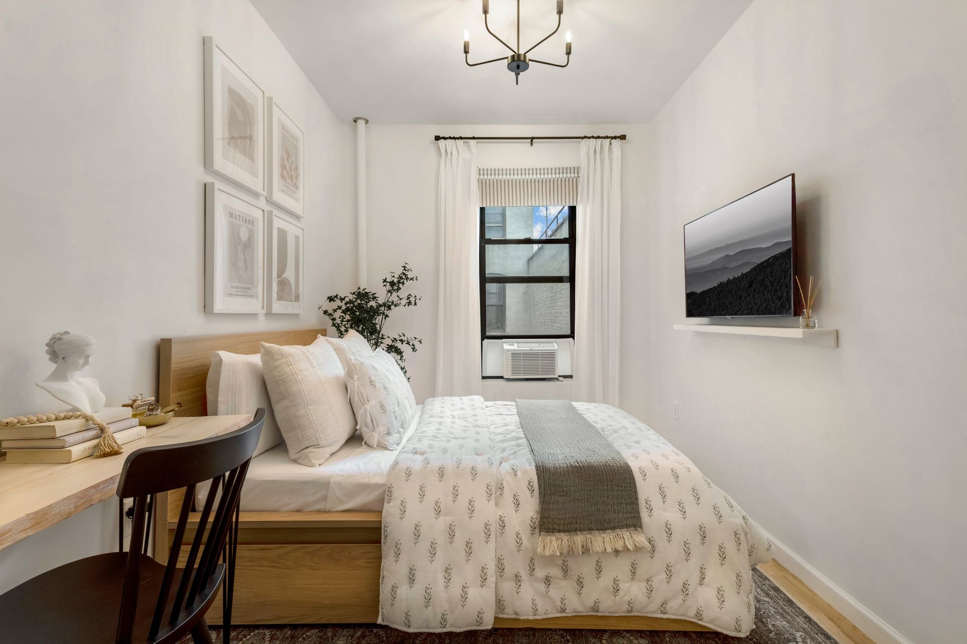 A bedroom with a bed , desk , chair and television.