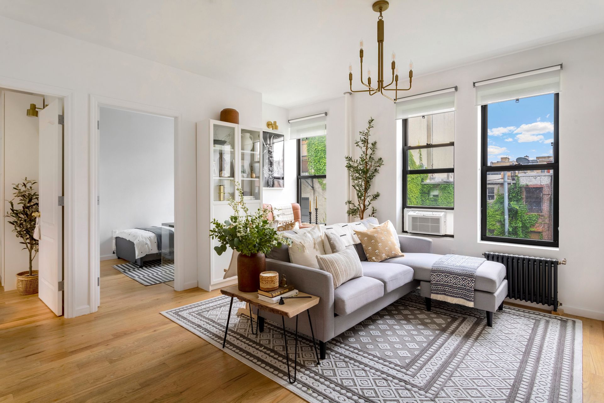 A living room with a couch , rug , and windows.