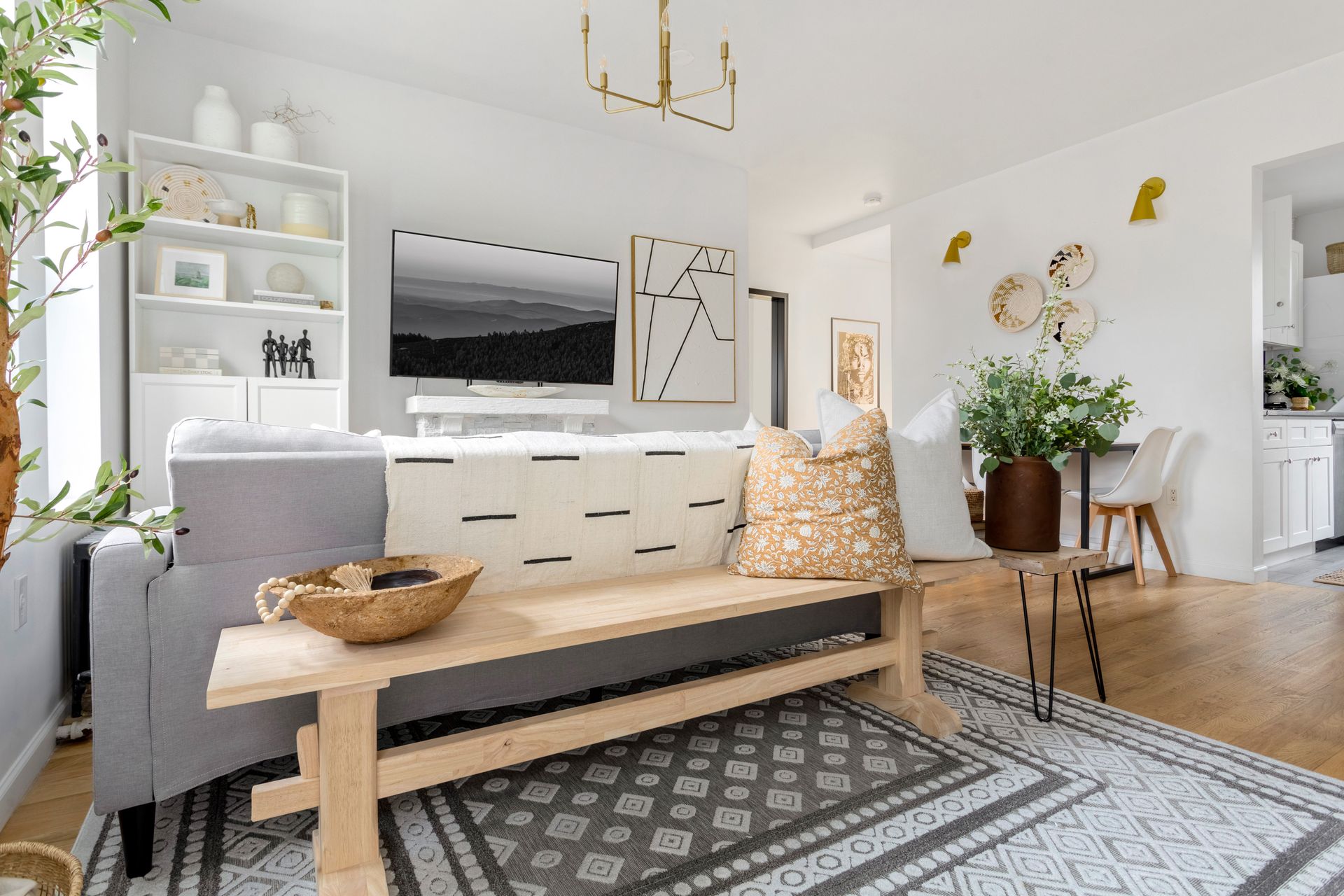 A living room with a couch , bench , rug and television.