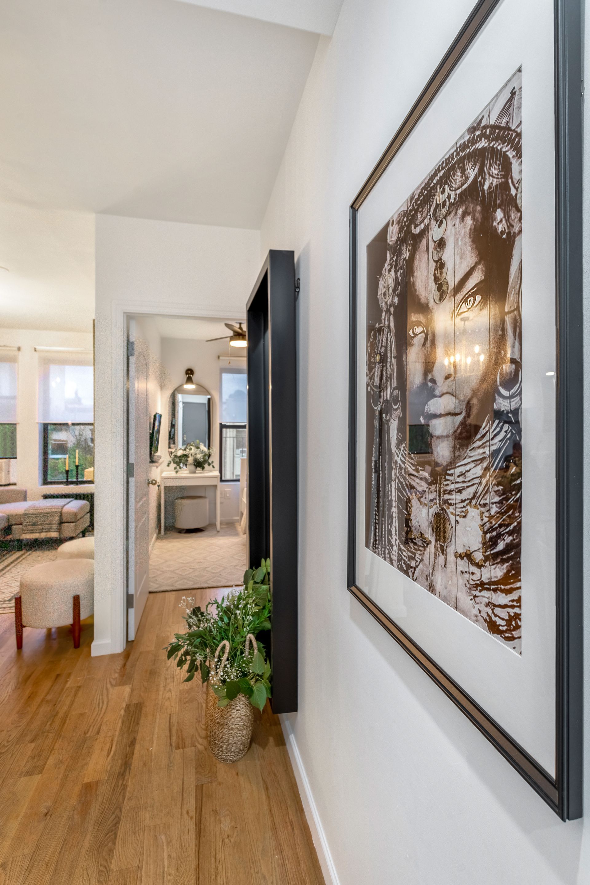 A picture of a woman is hanging on a wall in a hallway.