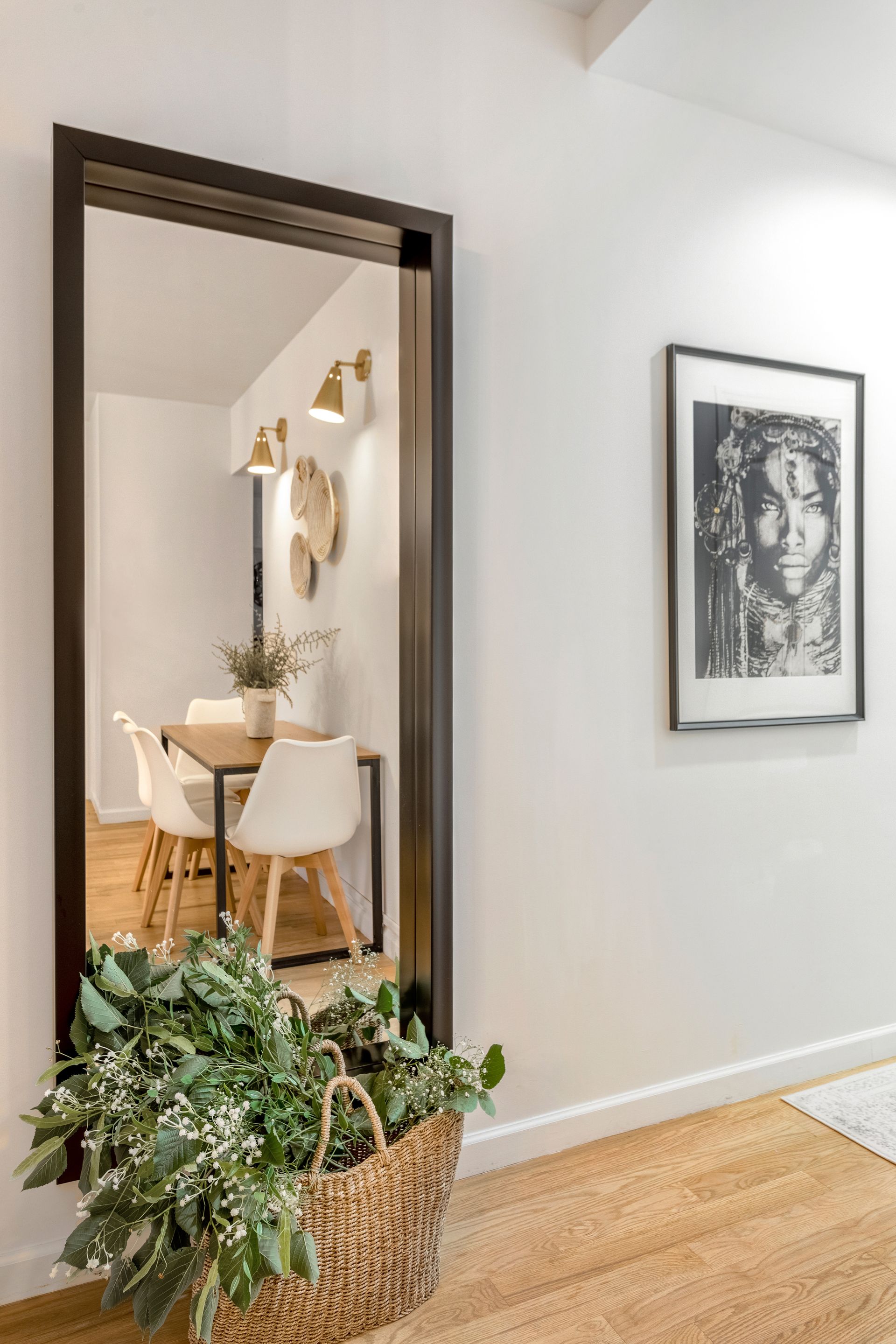 A hallway with a large mirror and a picture on the wall.