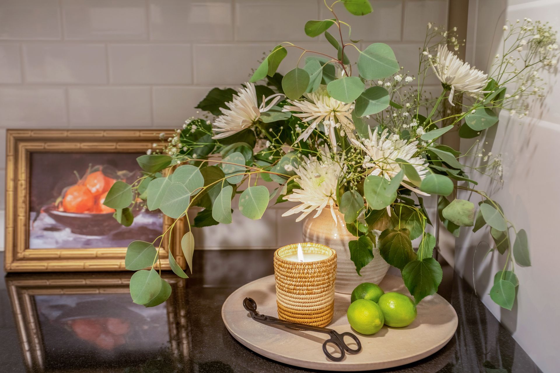A candle is sitting on a table next to a vase of flowers.