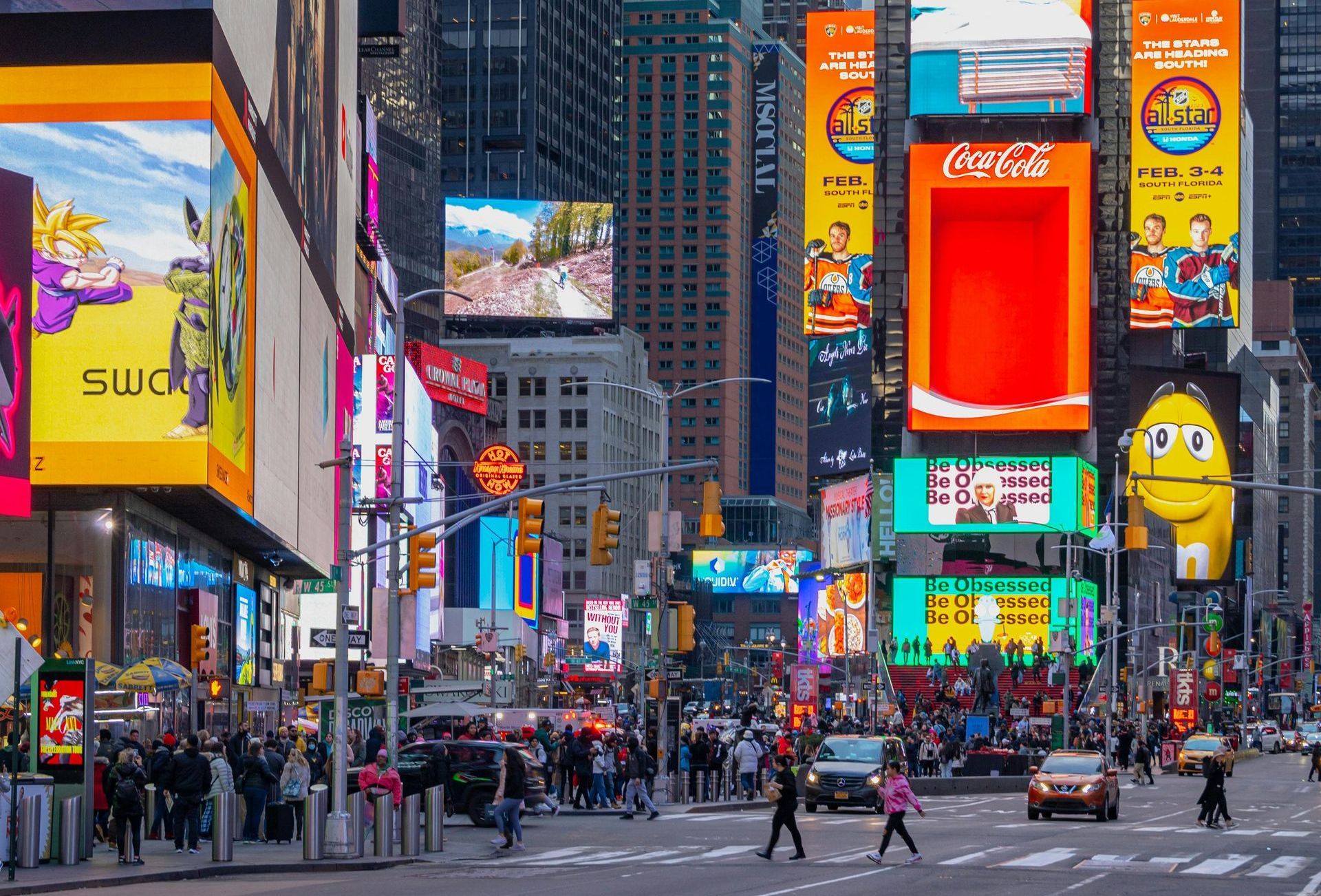 A busy city street with a lot of advertisements on the buildings.