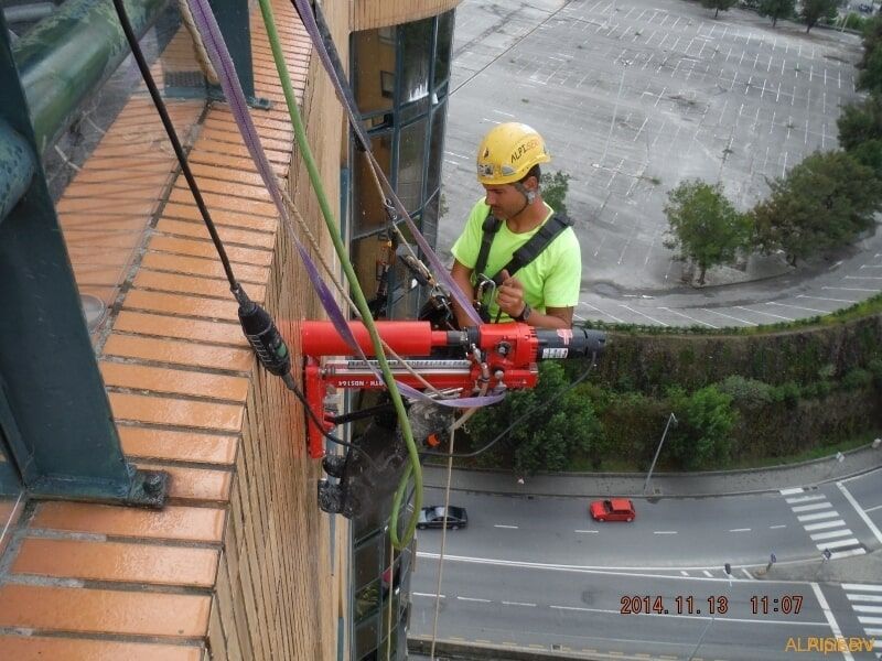 Um homem usando um capacete amarelo está trabalhando em um prédio