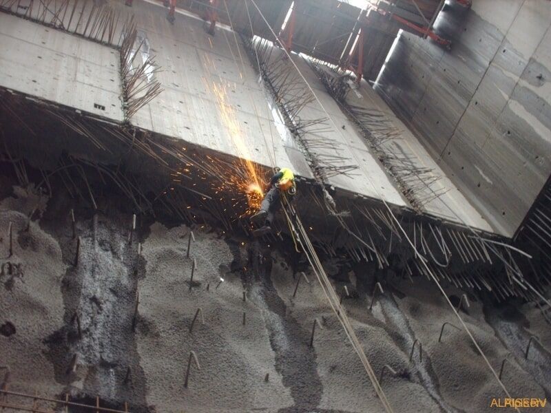 Uma pessoa está cortando um pedaço de concreto com uma máquina de solda