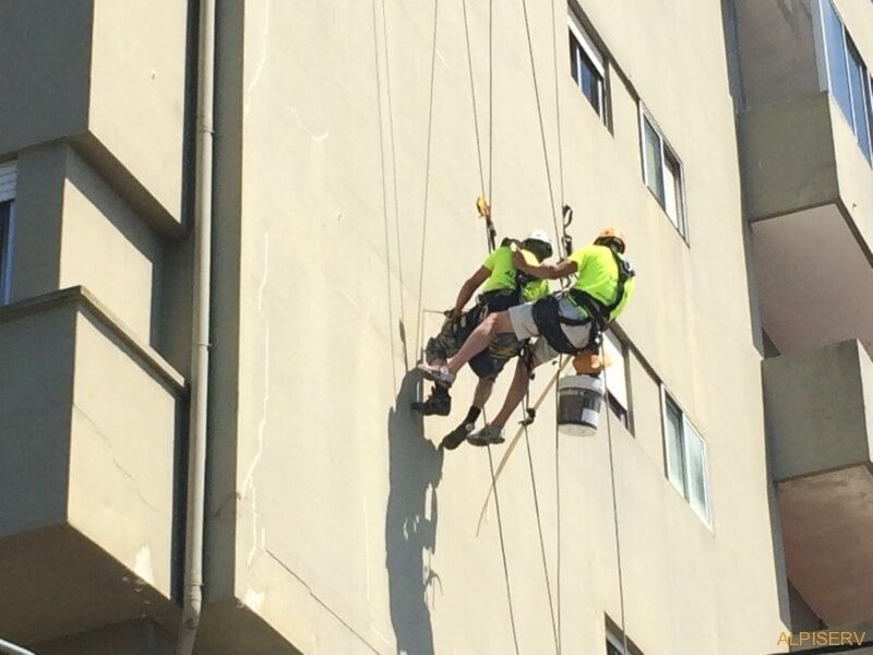 Um grupo de homens está escalando a lateral de um prédio
