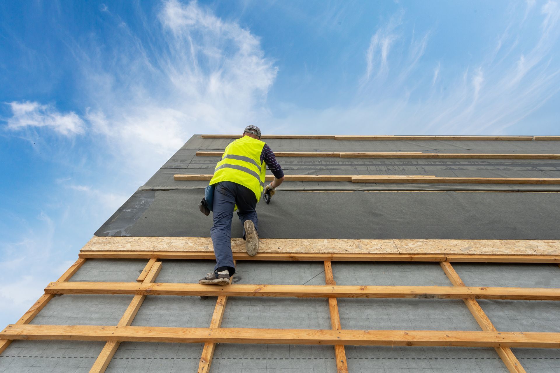 Ouvrier qui attache une membrane sur une toiture 