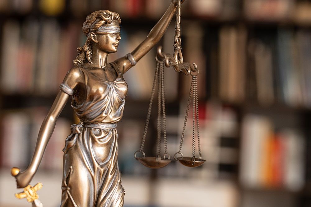 Justitia vor einem Bücherregal