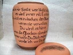 Beige Kerze mit deutschem Text neben einem passenden Deckel mit Wimpernmotiv.