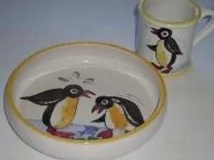 Teller und Becher mit Pinguinmotiven in Schwarz, Weiss und Gelb