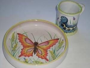 Schale und passender Becher mit Schmetterlingsmotiven und pastellfarbenen Blumen- und blauen Vogelmotiven