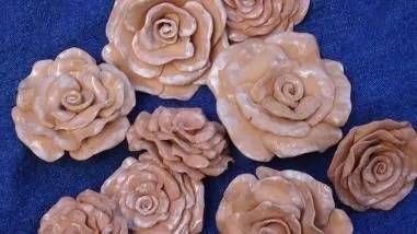 Verschiedene beige, blütenförmige Kekse oder Ornamente auf blauem Hintergrund