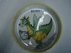 Ein gezeichneter Drache auf einem weissen Teller, darüber steht der Name „Alain“.