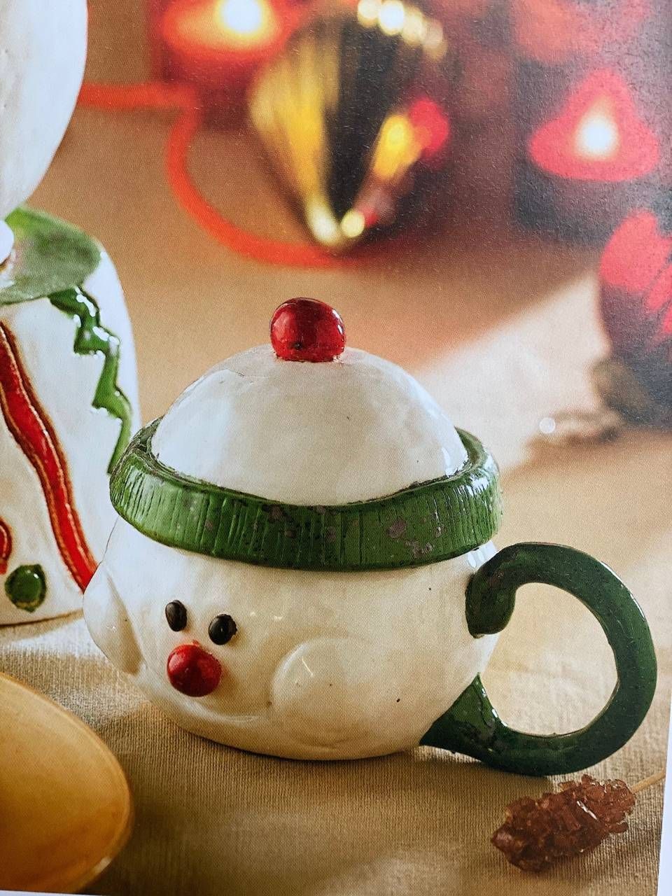 Teetassenförmiger Weihnachtsschmuck mit grünem Henkel, roter Nase und schneeweisser Spitze