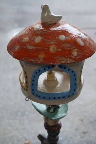 Kleines, dekoratives Vogelhaus mit rot gepunktetem Dach auf einer Stange