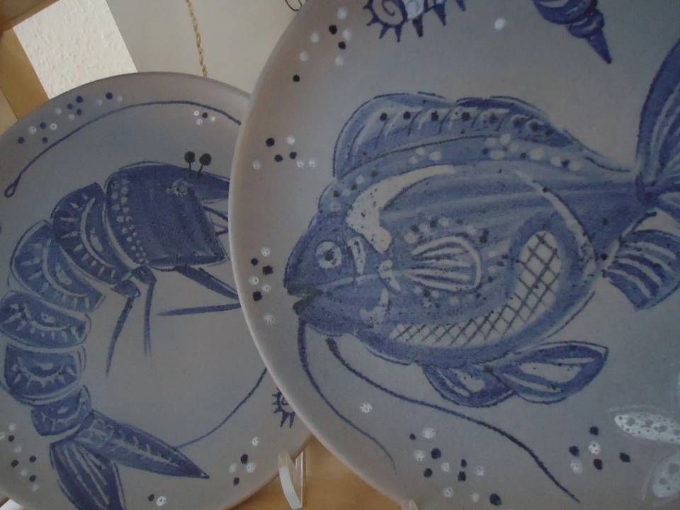 Blaue Fischillustrationen auf weissen Keramiktellern mit gepunkteten Dekormustern