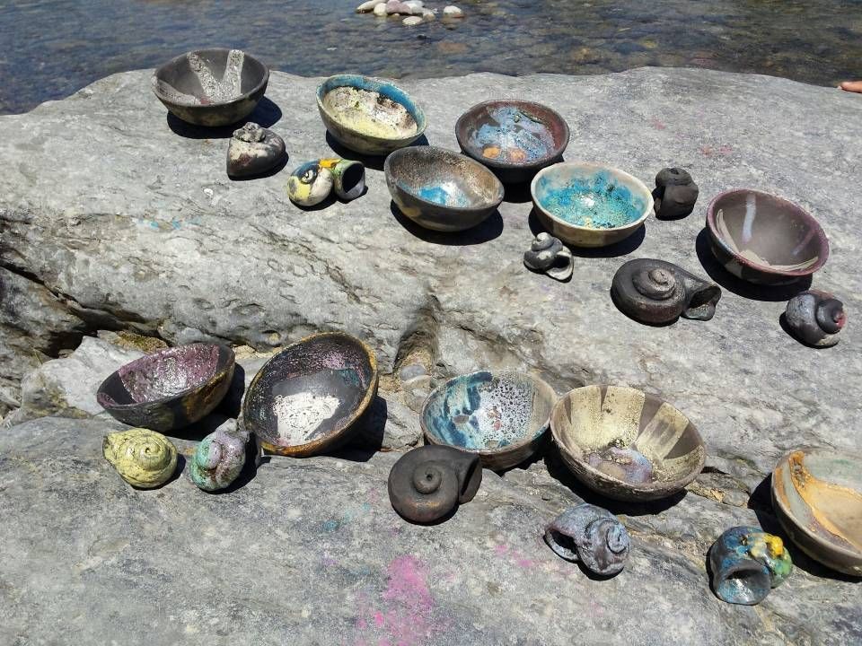 Verschiedene kleine Schalen und Becher waren auf einem Stein neben fliessendem Wasser angeordnet.