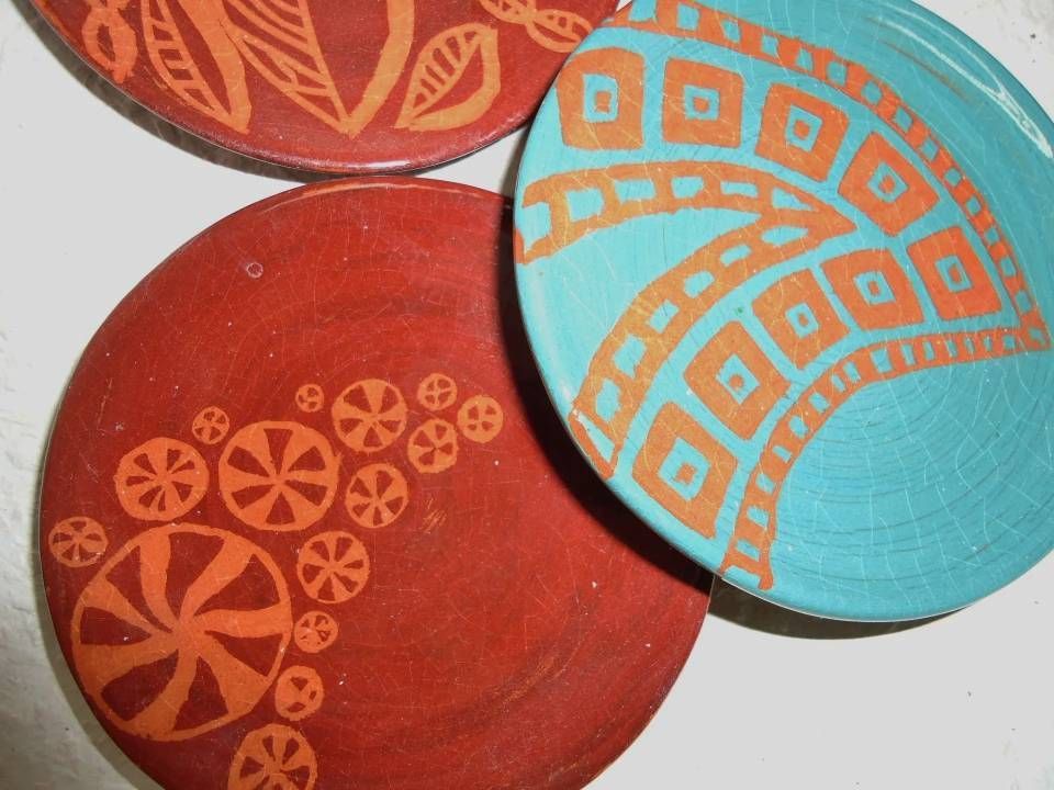 Drei dekorative runde Teller mit geometrischen Mustern in Rot, Türkis und Orange.