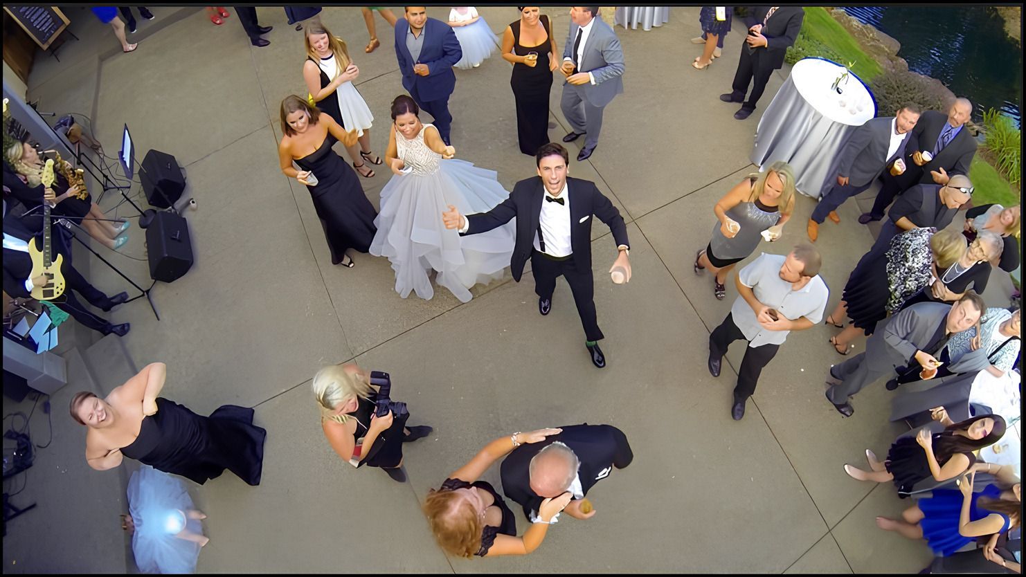 Les invités d'un mariage les bras en l'air.