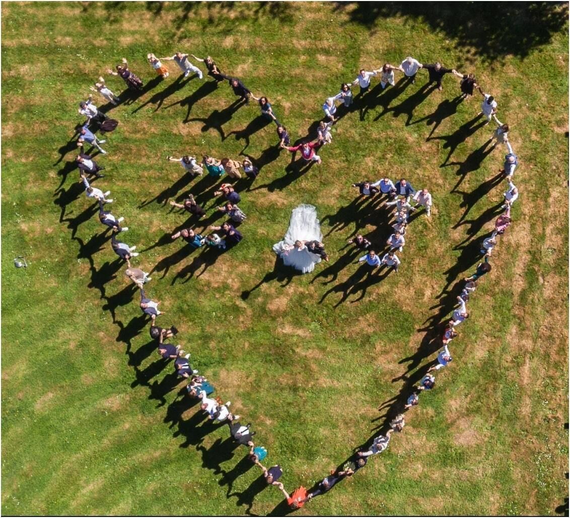 Des gens forment un cœur sur l'herbe.